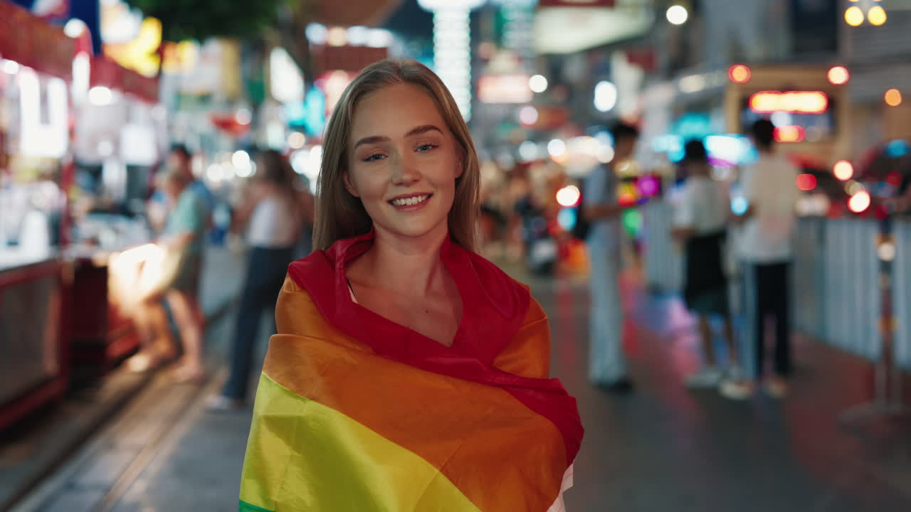 Woman with Rainbow Flag in City at Night