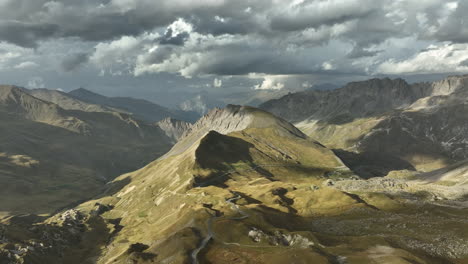 pass road going through tunnels in the mountain french alps aerial shot