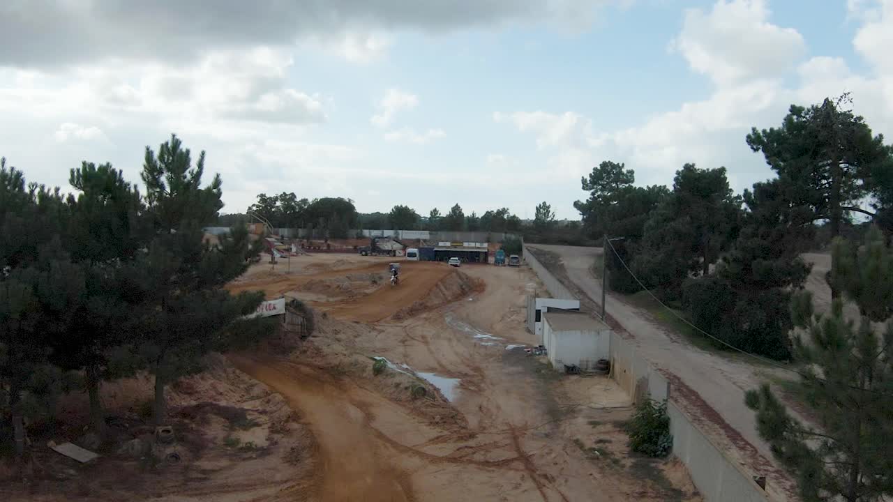 piloto de motocross dando vueltas y saltando sobre una rampa de tierra en un circuito