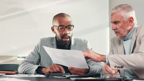 two businessmen discussing documents in a meeting