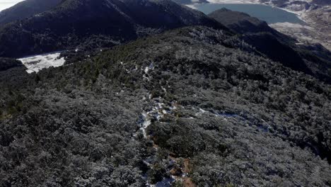 Hiker-ascending-high-Jade-Dragon-Mountain-on-cold-frost,-Yunnan-China,-aerial