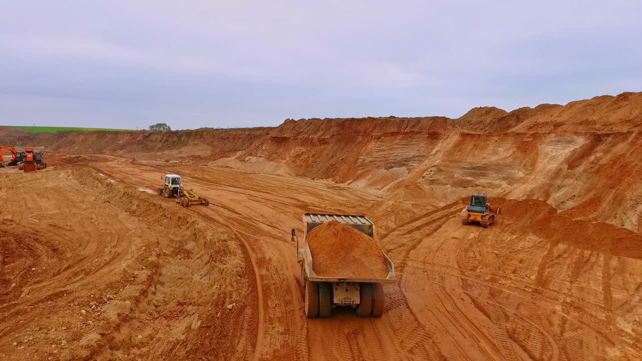 Dumper truck transporting sand in quarry. Aerial view of sand work