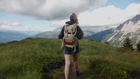 Blick-Von-Hinten-Auf-Eine-Wandertouristin-Mit-Rucksacktrekking-Und-Wandern-Auf-Einem-Bergpfad-Mit-Den-Dolomiten-Im-Hintergrund