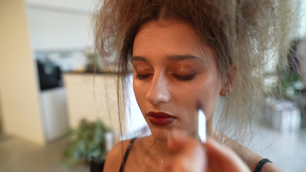 Close-up of Young Woman Getting Eyeshadow Applied by Makeup Artist
