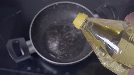 pouring cooking oil into a frying pan