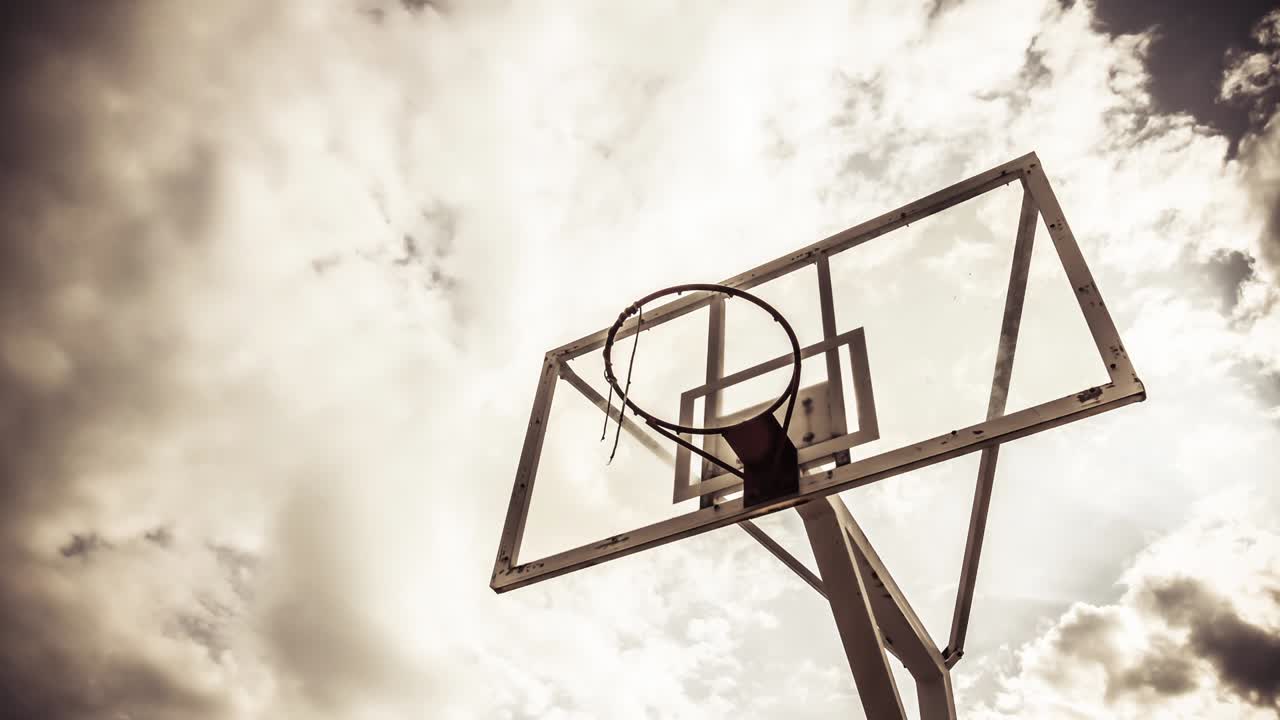 el fondo de la nube dramáticamente en movimiento de un anillo de baloncesto en color cálido