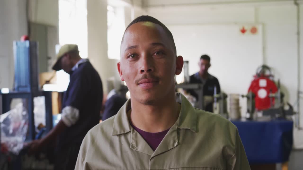 vista frontal de un trabajador de raza mixta en una fábrica