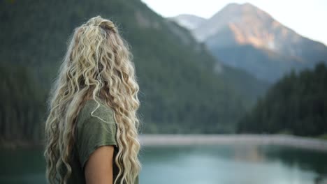 slow motion shot of a happy beautiful blonde female overlooking a gorgeous scene in the mountains