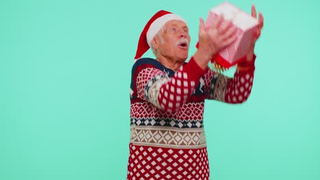 Grandfather-man-in-sweater-Santa-Christmas-getting-present-gift-box,-expressing-amazement-happiness