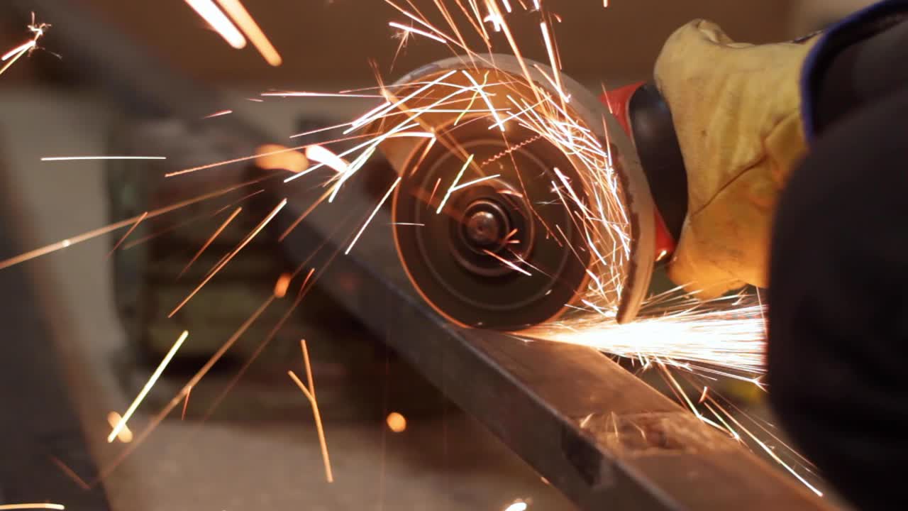 Hand saw grinder with safety gloves cutting metal, closeup