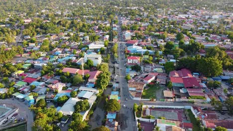 descenso de drones aéreos para revelar un paisaje montañoso y accidentado que rodea la capital dili, timor leste en el sudeste asiático, con casas residenciales, negocios y tráfico