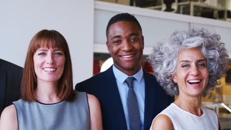 group of business partners smiling to camera in an office