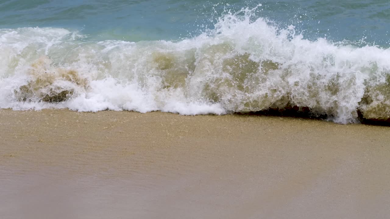 Close up view over waves breaking on tropical beach