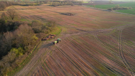 pesticide spraying tractor working in large field at sunset,aerial shot