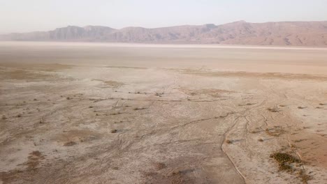 landing in salt lake desert in mountain foothill rural countryside the wide panoramic view of drought climate dry landscape hot summer hazy day in iran poverty agriculture concept farm land fig tree