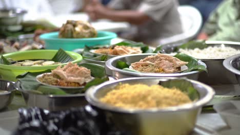 traditional indonesian wedding food in banana leaves,with people in background