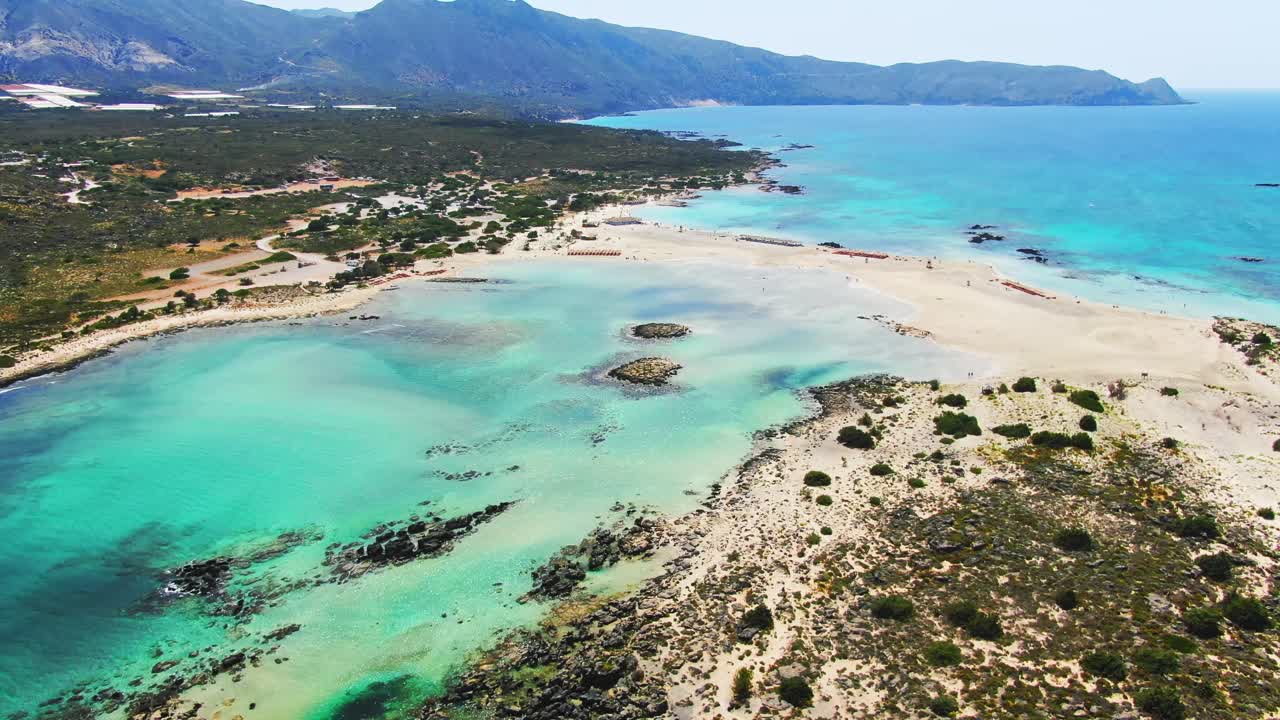 Vista aérea rotatoria de la laguna de Elafonisi, Creta, Grecia, que muestra arena rosa y banco de arena con aguas poco profundas. Vista a vista de pájaro