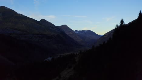 Disparo-De-Un-Dron-Que-Va-Hacia-Atrás-De-Un-Valle-Vacío-De-Montañas-Durante-La-Noche