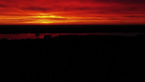 Red-Magical-Sky-and-Sunset-over-River,-Aerial-Side-Dolly