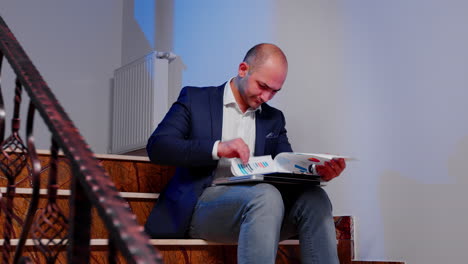 businessman analyzing documents sitting on stairs