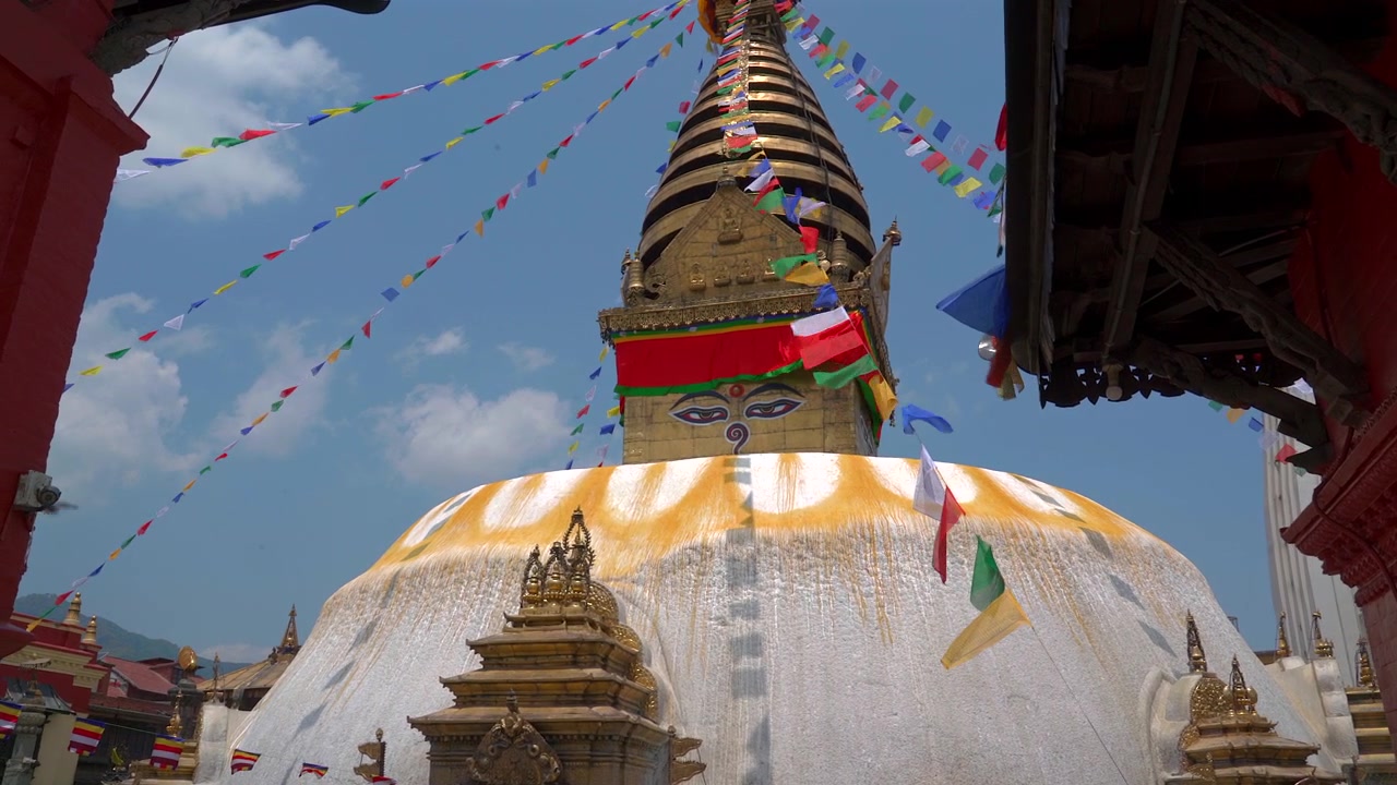 Matala seurantakuva historiallisesta Swayambhunathin apinatemppelin kupolista ja tornista, jota koristavat värikkäät buddhalaiset rukousliput kirkkaan sinisen taivaan alla Kathmandussa, Nepalissa.