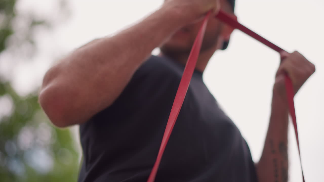 White Male Hands Gripping Red Resistance Band Close, Strength Coach Detail Shot Capturing Tension, Veins And Wrist Movement, Low Angle Perspective Emphasizing Force And Technique During Setup And Pull