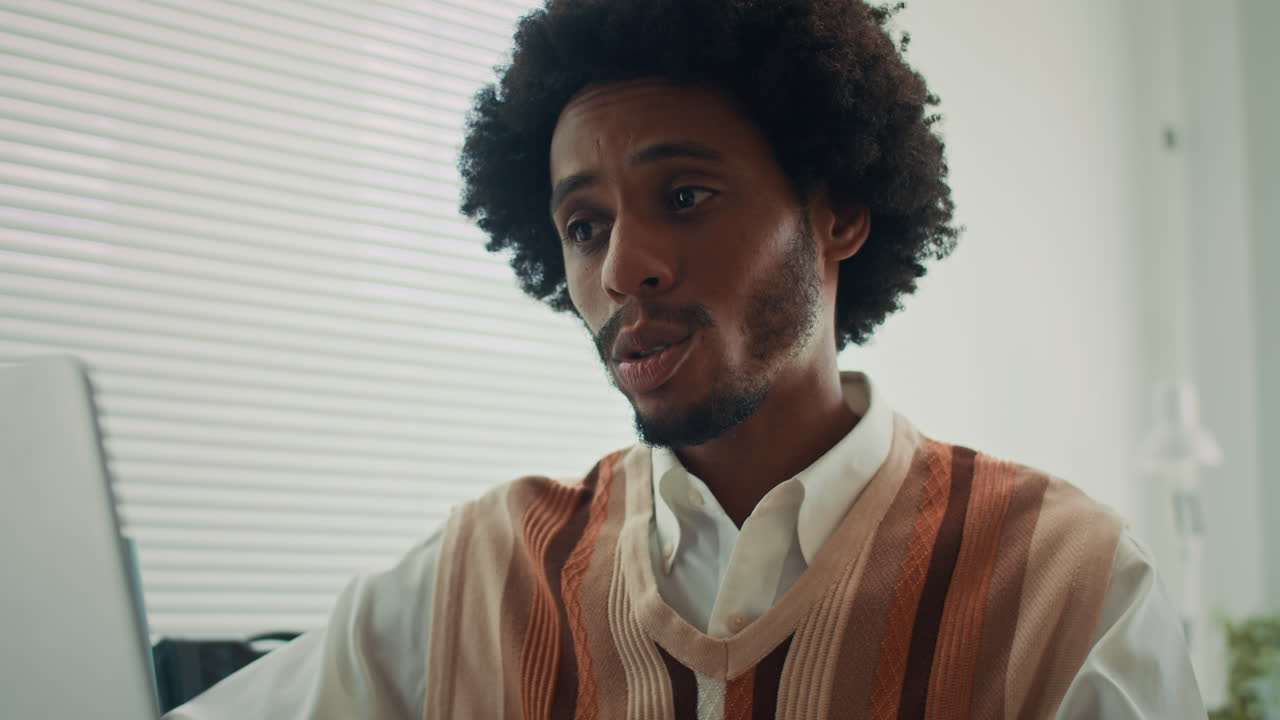 Male Manager Having Coffee when Conferencing Online via Laptop