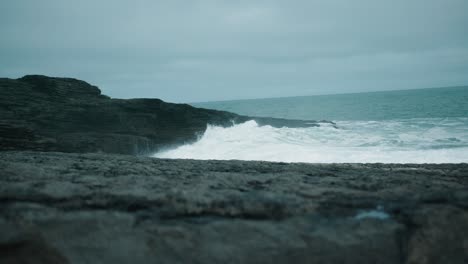 ozean waves crashing against the irish shore on a stormy day