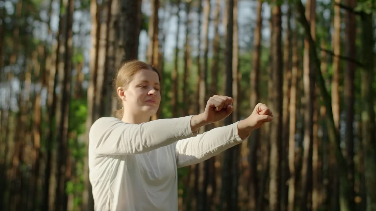 Woman practicing Tai Chi in forest