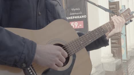 man playing acoustic guitar outdoors