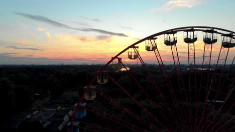 Silhouette-of-Ferris-Wheel-in-Abandoned-Amusement-Park,-Drone-Aerial-View-of-Berlin-Sunset-Skyline-From-Spreepark