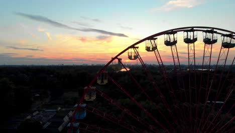 silueta de rueda de ferris en parque de atracciones abandonado, vista aérea de drones del horizonte de la puesta de sol de berlín desde spreepark
