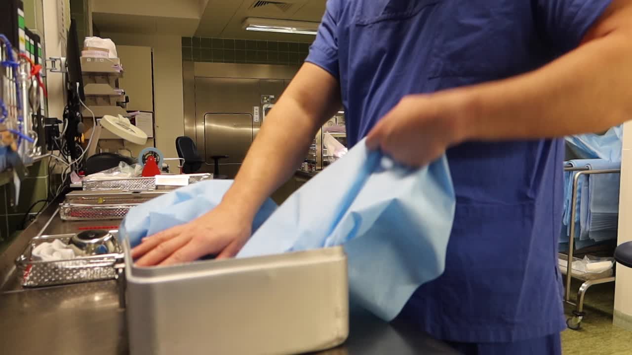 un impiegato di un reparto chirurgico imballa gli strumenti puliti in un contenitore