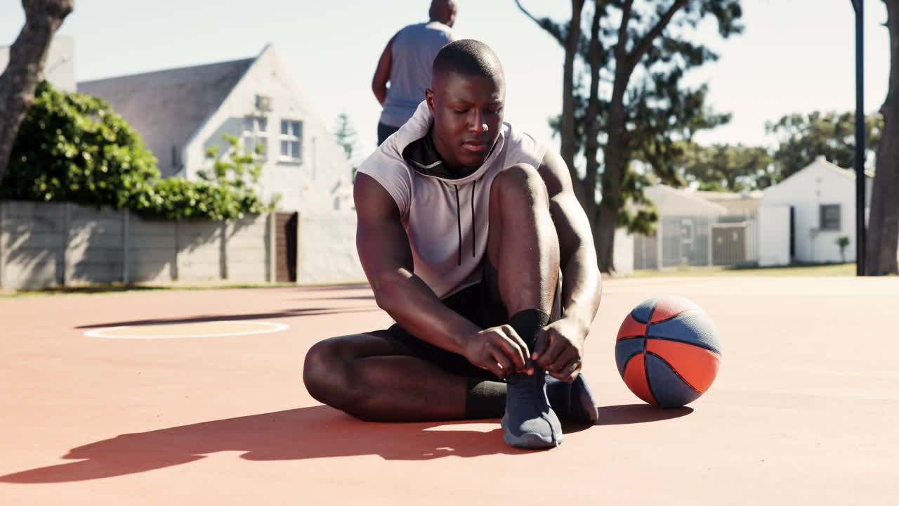 Athlete tying his shoes on the basketball court