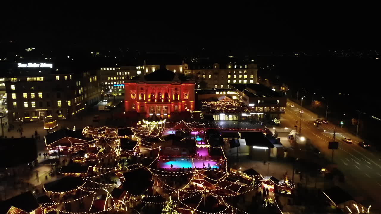 스위스 취리히에 있는 크리스마스 시장의 낮은 드론 샷이 뒤로 날아 밤에 시장을 드러낸다