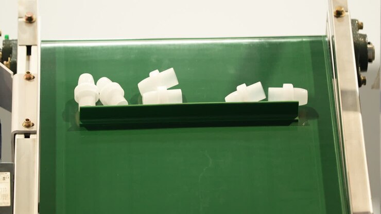 Finished Plastic Parts On Conveyor Belt For Packing