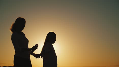 A-Woman-Spray-Spray-From-Insects-On-Her-Daughter-Silhouettes-At-Sunset-Rest-Without-Harmful-Insects