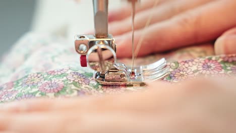 Sewing-machine-needle-working-on-colorful-cloth,-close-up-view