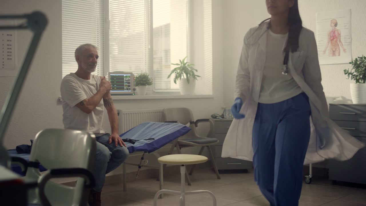 건강 클리닉에서 노인 환자 백신 주사를 상담하는 혼합 인종 의사