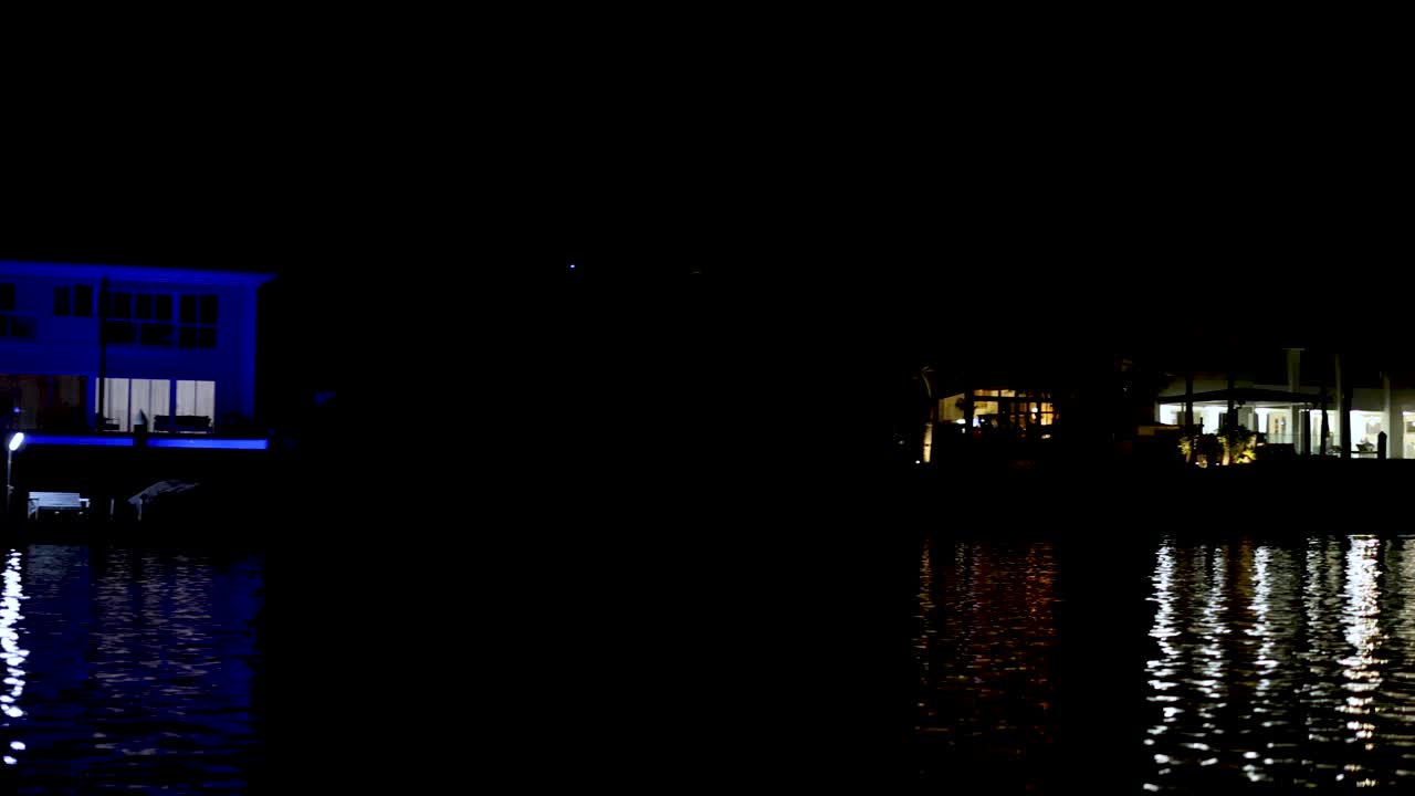 освещенные дома на набережной, отражающие воду