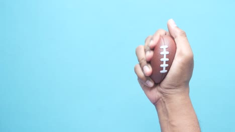 hand holding a miniature football