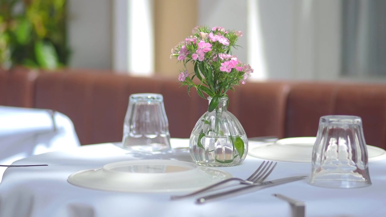 Small Vase of Pink Flowers on a Restaurant Table