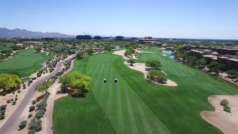 Aerial-hight-angle-long-distance-tilt-down-on-golfer-and-carts-in-the-fairway,-​Scottsdale