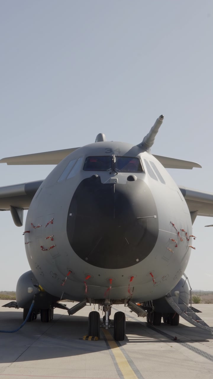 Aereo da trasporto militare parcheggiato frontalmente.
