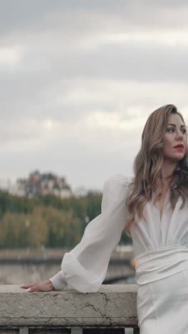 elegant woman in white dress on a bridge