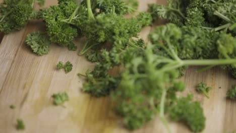 Parsley-leaves-are-dropped-on-a-wooden-table