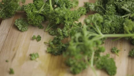 parsley leaves are dropped on a wooden table