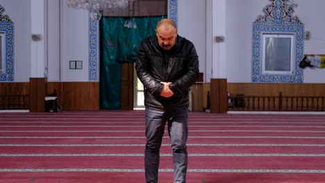 older muslim man worships and prays in mosque