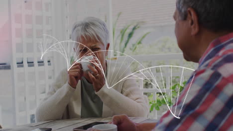 senior couple sipping coffee on veranda, featuring smartphone tablet graphics for technology design