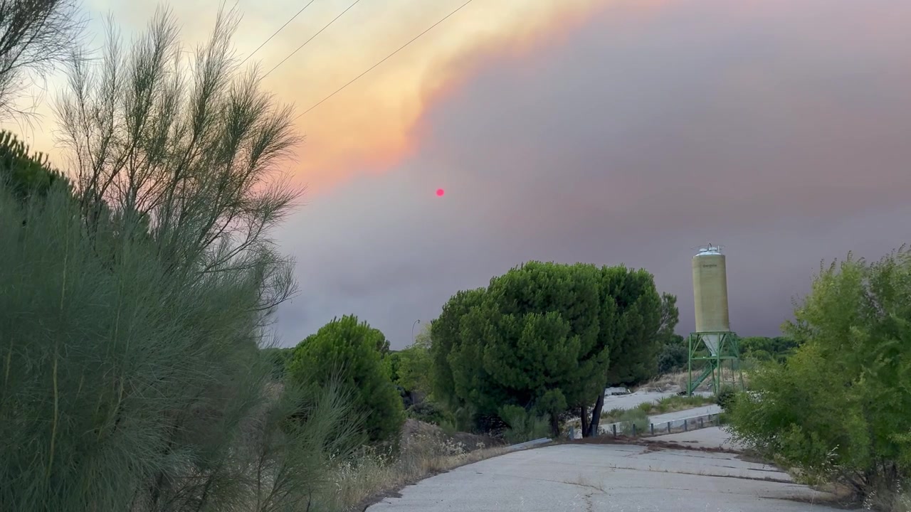 Una nube de humo de un incendio oscureciendo el sol rojo. Una escena apocalíptica